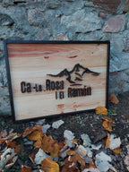 Letrero de madera con paisaje de montañas, otra vista