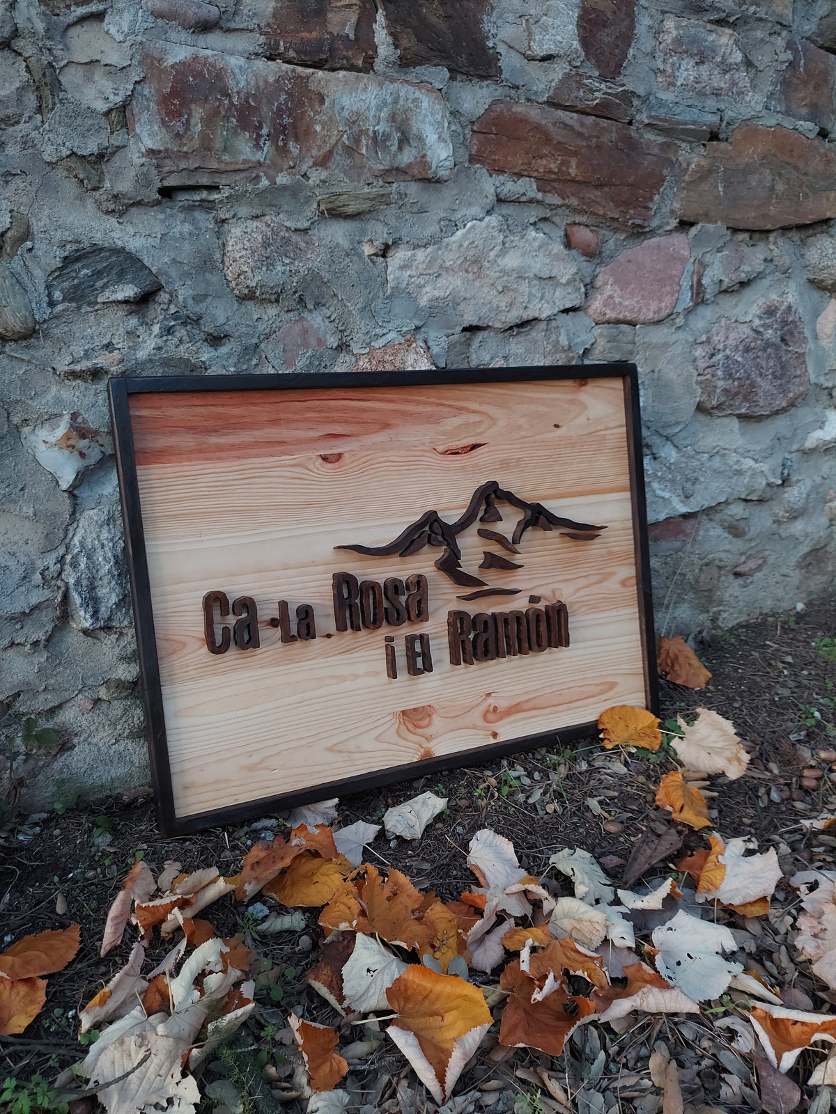 Letrero de madera con paisaje de montañas, detalle