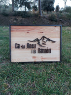 Letrero de madera con paisaje de montañas, vista lateral